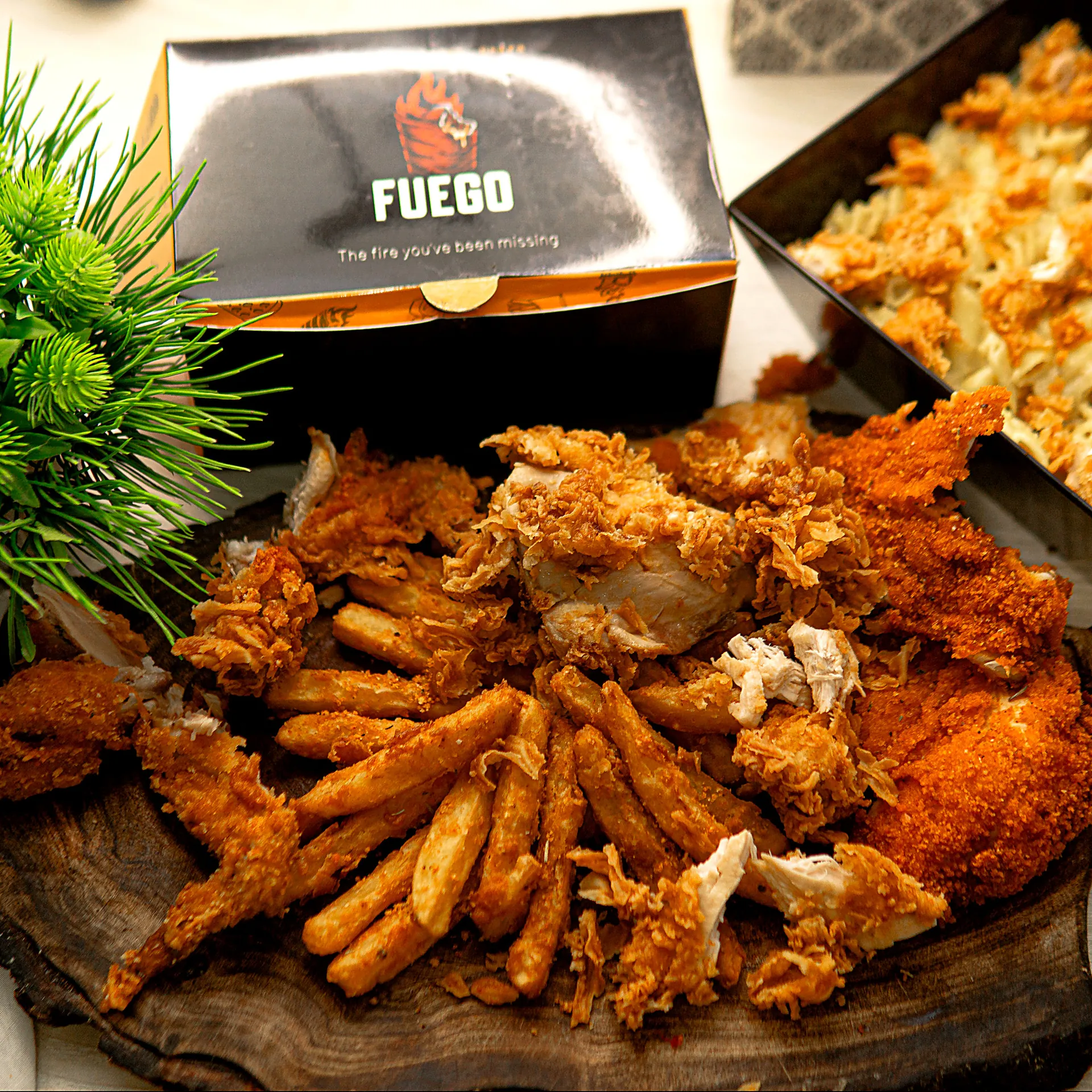 A Fuego box overflowing with fried chicken, strips and masala fries