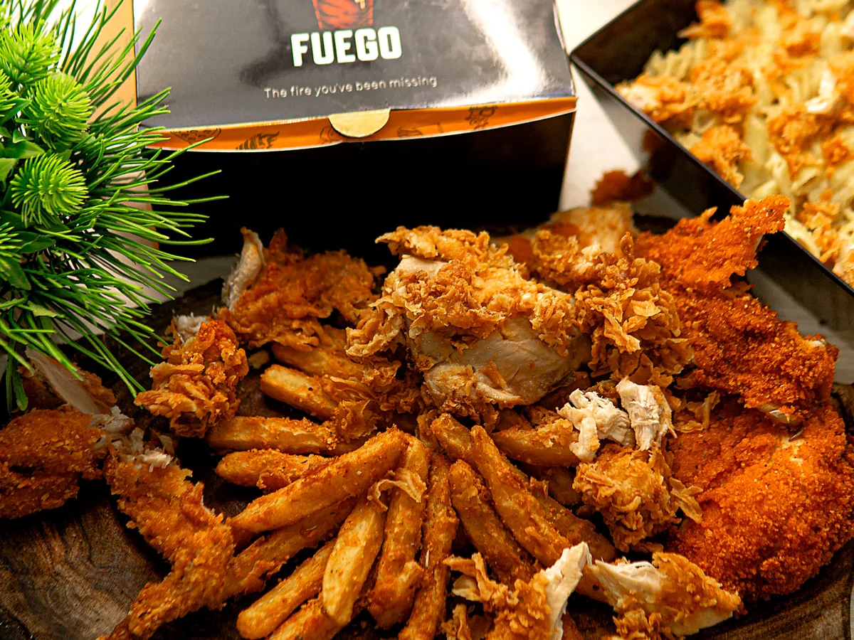 A Fuego box with fried chicken, strips and fries